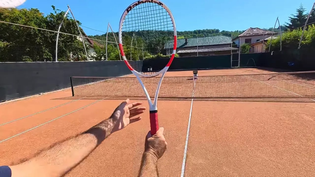 Racket held upright with the dominant hand on the grip